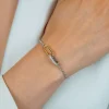 ZINZI zilveren schakelarmband met twee verbonden ovale schakels: ene gold plated, ander bezet met witte zirkonia's ZIA2758